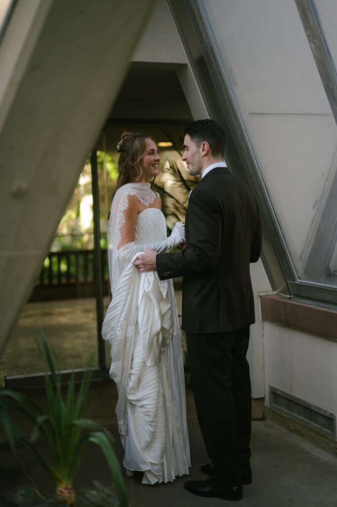 Bride and groom facing each other full of excitement as they exit the botanic gardens