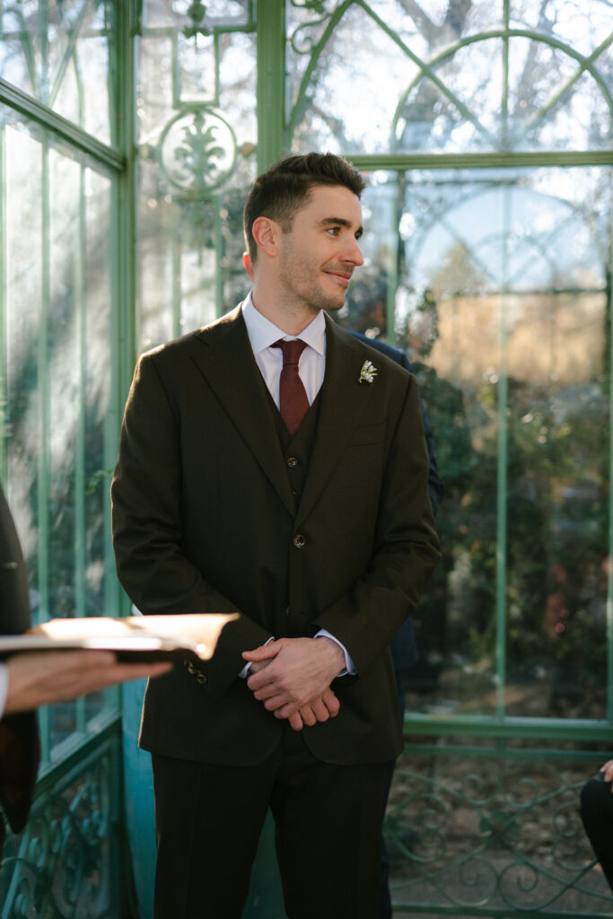 Groom waiting for bride as she comes down the aisle