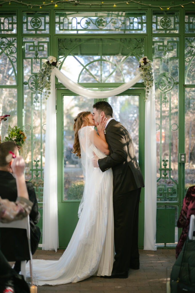 Bride and groom sharing first kiss as a newly married couple