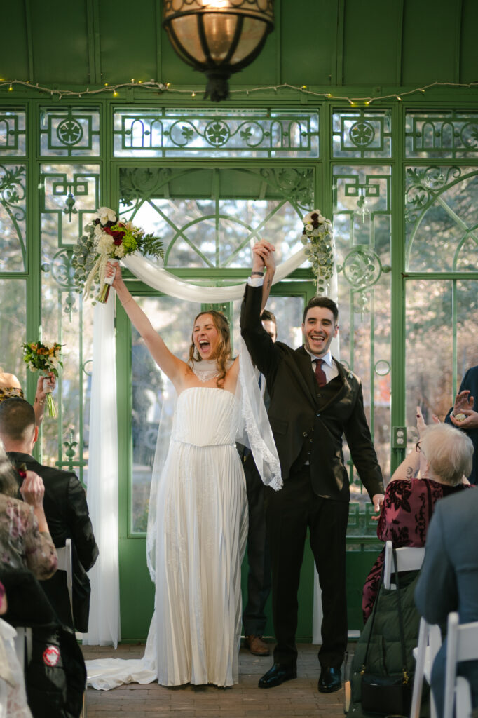 Excitement from bride and groom as they just shared their first kiss and turned towards crowd