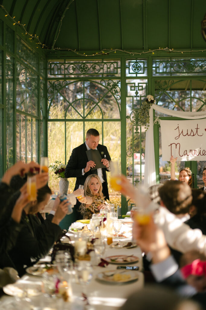 Father of the bride giving a speech at brunch and everyone raising their glasses