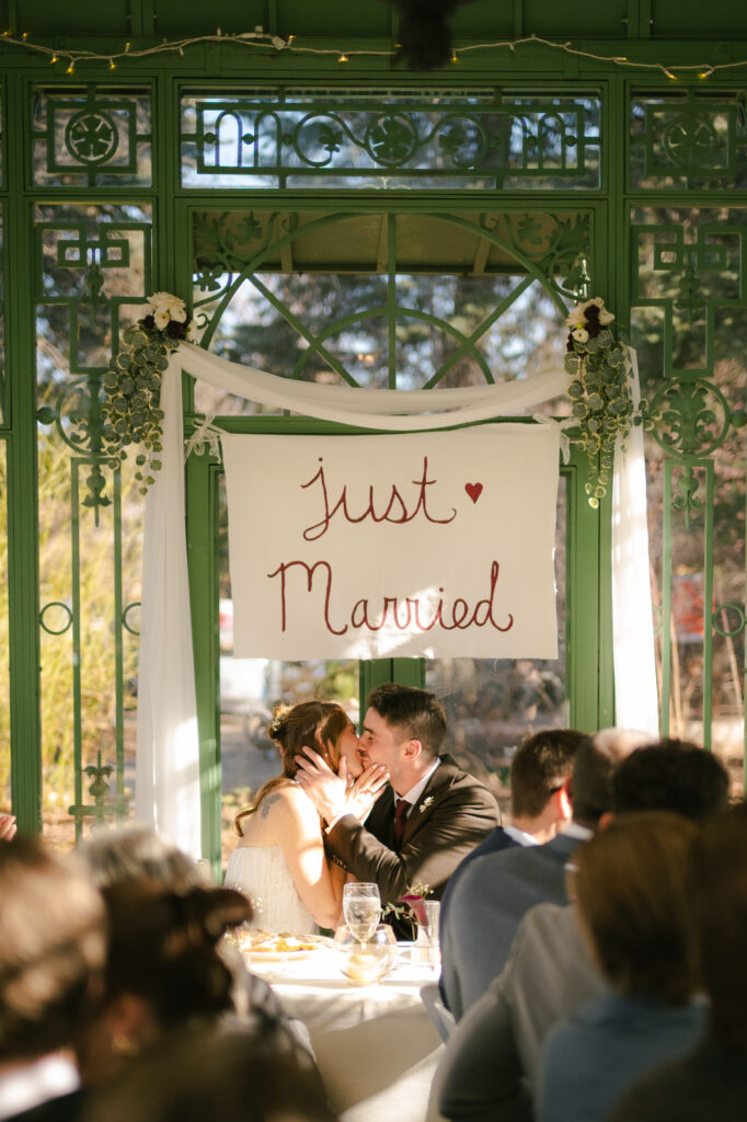 Bride and groom kissing after guest rang bells during brunch after ceremony