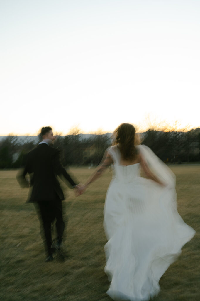 Bride and groom running away from camera