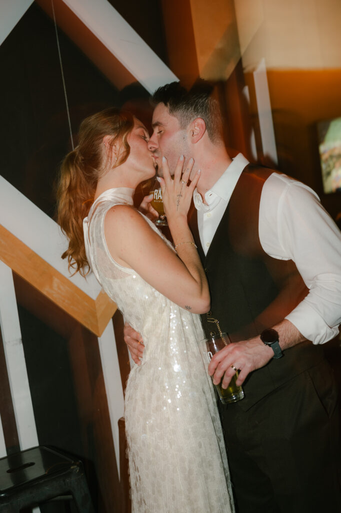Bride and groom kissing in bar