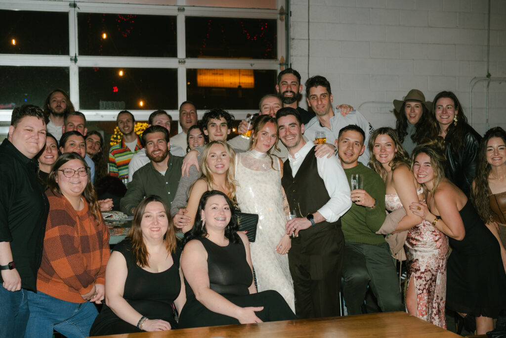 Flash group photo in bar with bride and groom